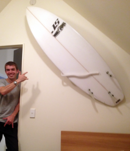 surfboard racked in bed room